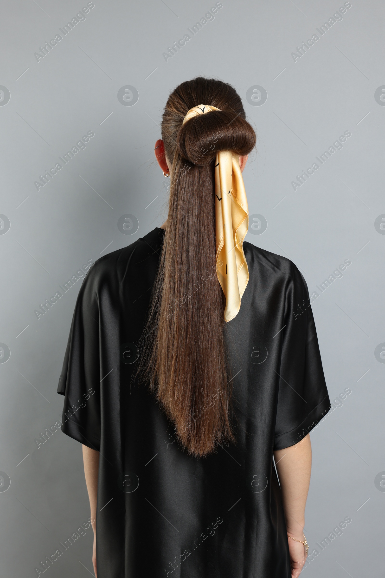 Photo of Teenage girl with stylish bandana on light grey background, back view