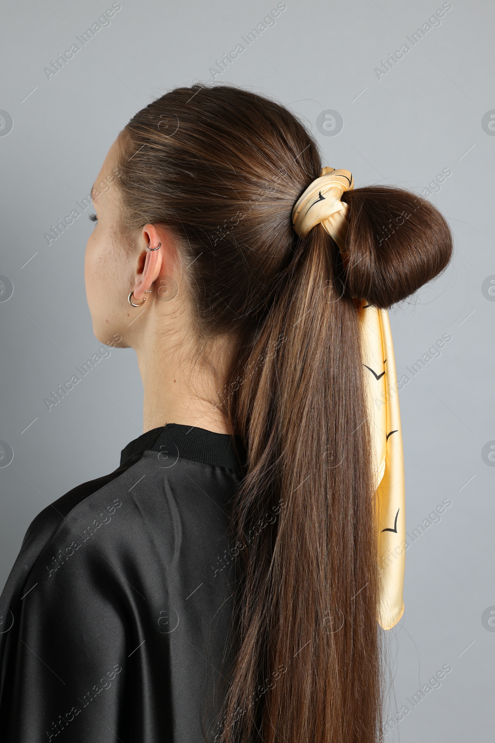 Photo of Teenage girl with stylish bandana on light grey background, back view