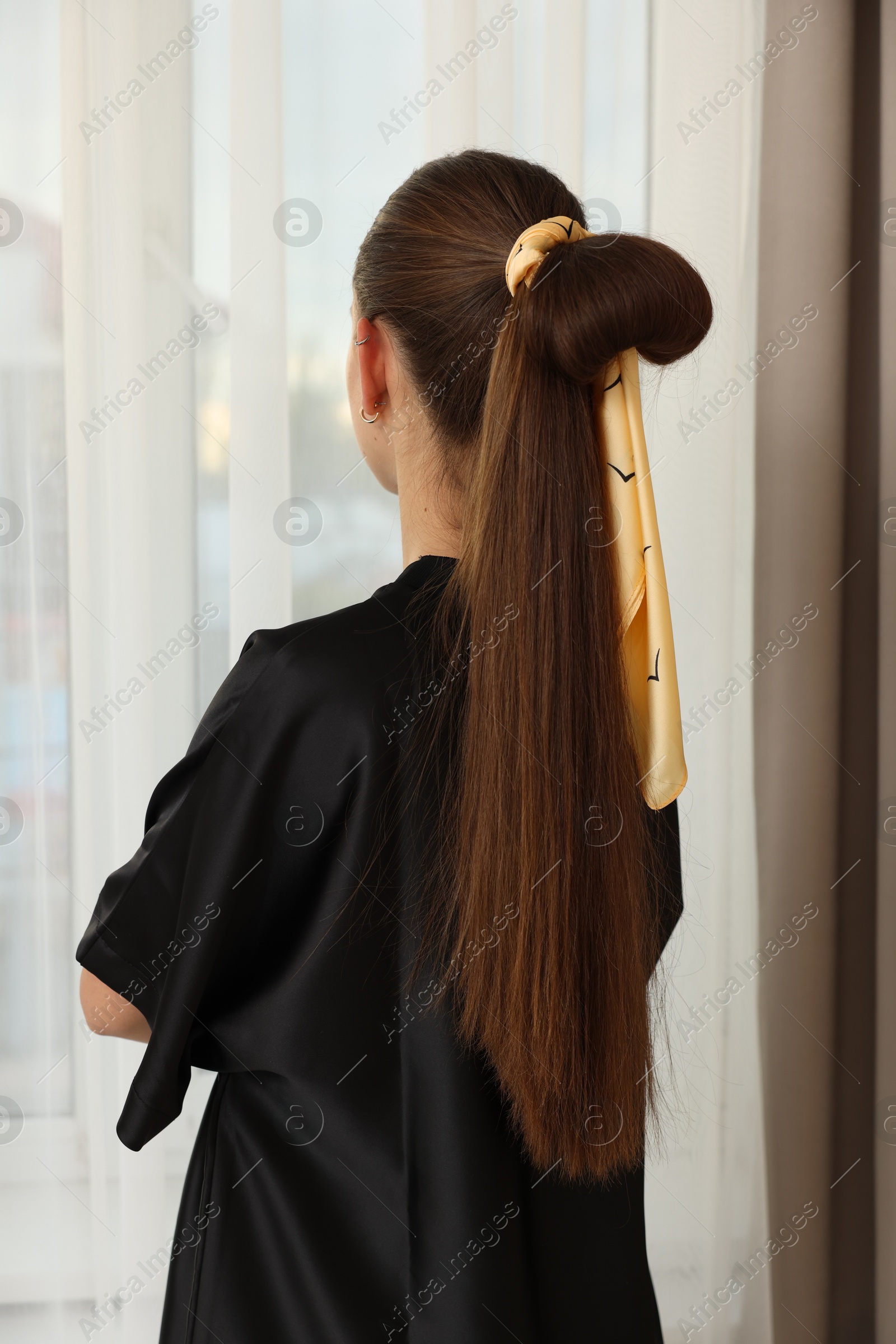 Photo of Teenage girl with stylish bandana indoors, back view