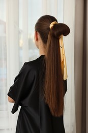 Photo of Teenage girl with stylish bandana indoors, back view