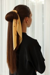 Photo of Teenage girl with stylish bandana indoors, back view