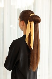 Photo of Teenage girl with stylish bandana indoors, back view