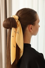 Teenage girl with stylish bandana indoors, back view