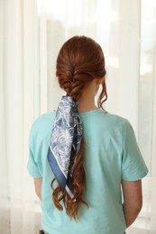 Teenage girl with stylish bandana indoors, back view