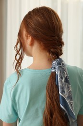 Photo of Teenage girl with stylish bandana indoors, back view