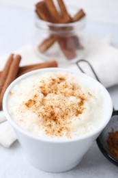 Photo of Delicious rice pudding with cinnamon on light table, closeup