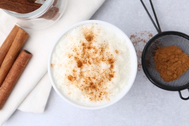 Photo of Delicious rice pudding with cinnamon on light table, flat lay