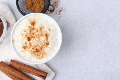 Photo of Delicious rice pudding with cinnamon on light table, flat lay. Space for text