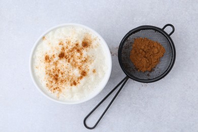 Photo of Delicious rice pudding with cinnamon on light table, top view