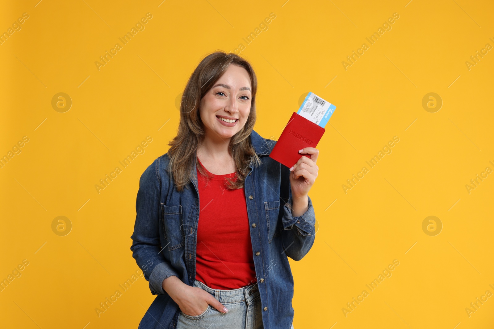 Photo of Happy traveller with passport and ticket on yellow background