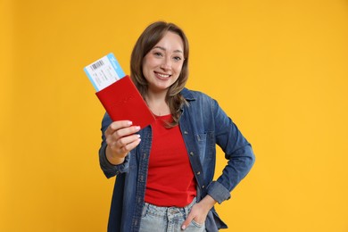 Photo of Happy traveller with passport and ticket on yellow background