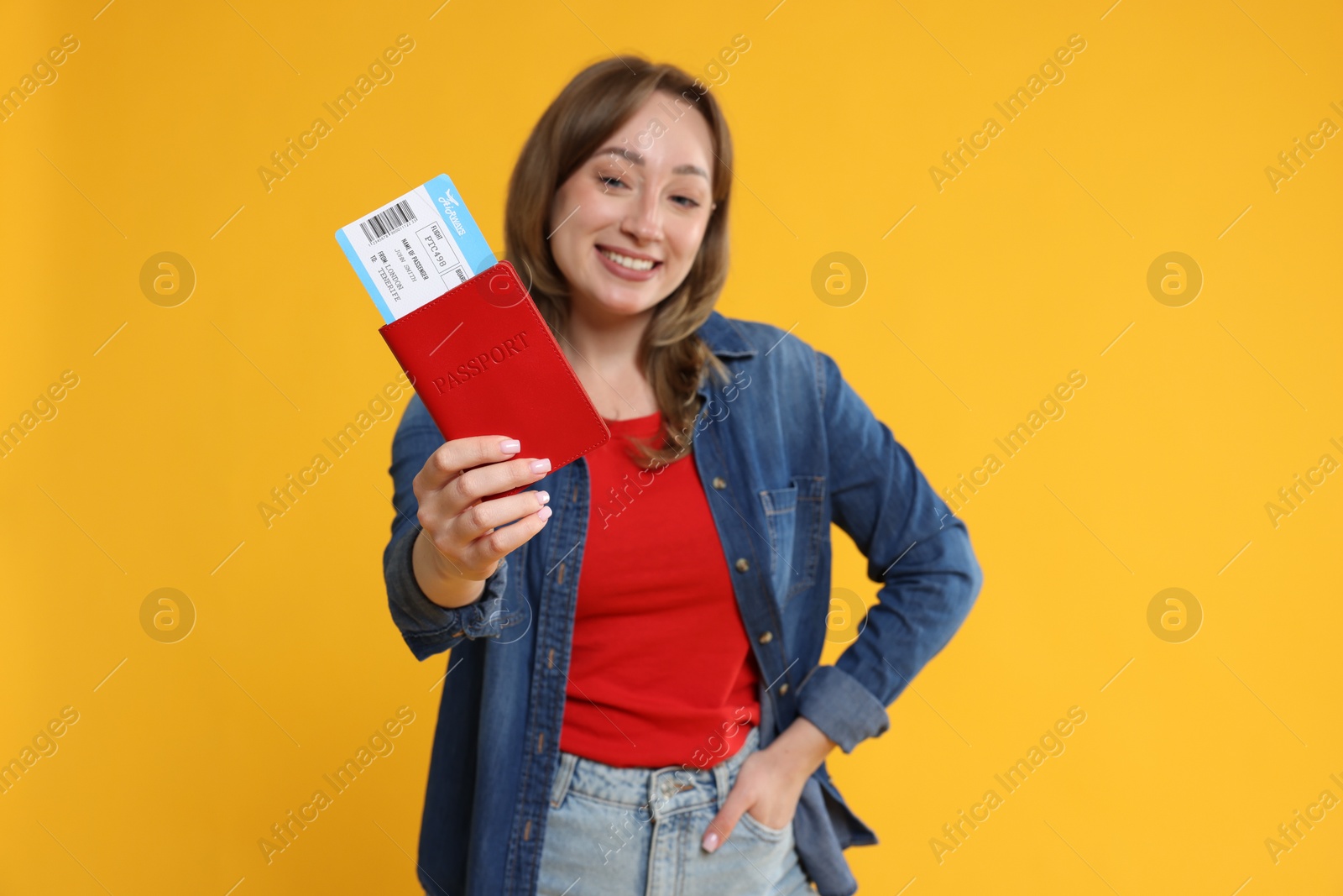 Photo of Happy traveller with passport and ticket on yellow background, selective focus