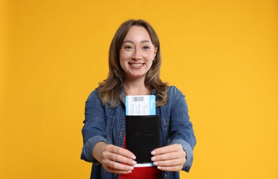 Photo of Happy traveller with passport and ticket on yellow background