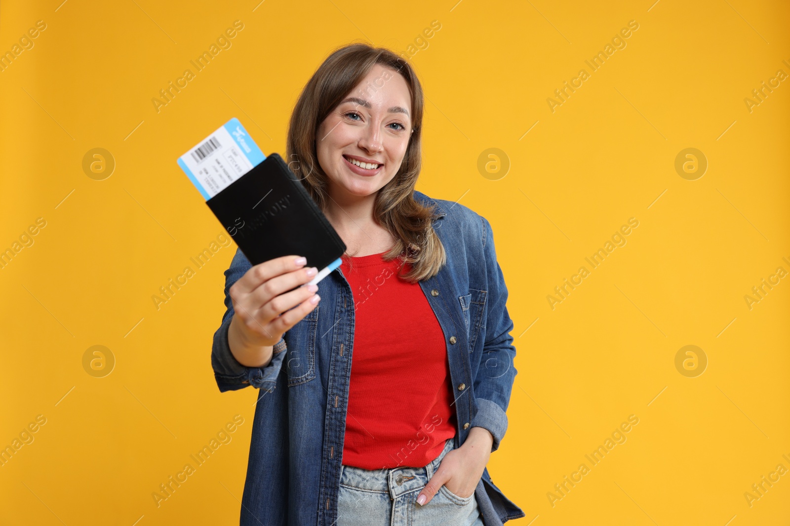 Photo of Happy traveller with passport and ticket on yellow background