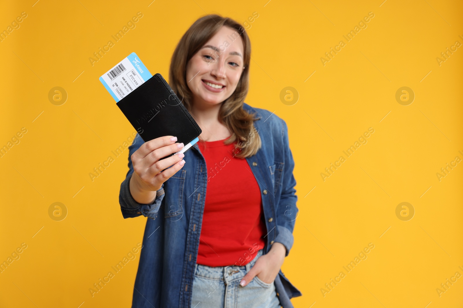 Photo of Happy traveller with passport and ticket on yellow background, selective focus