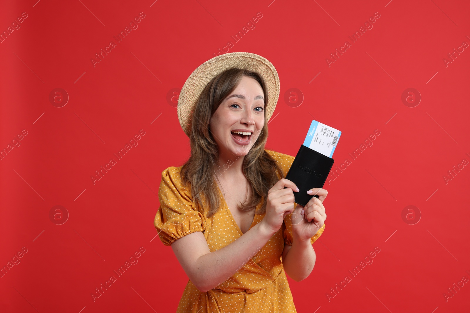 Photo of Happy traveller with passport and ticket on red background