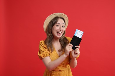 Photo of Happy traveller with passport and ticket on red background