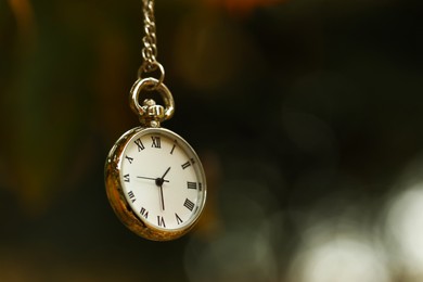 Photo of Autumn time. Chain watch on blurred background, closeup with space for text