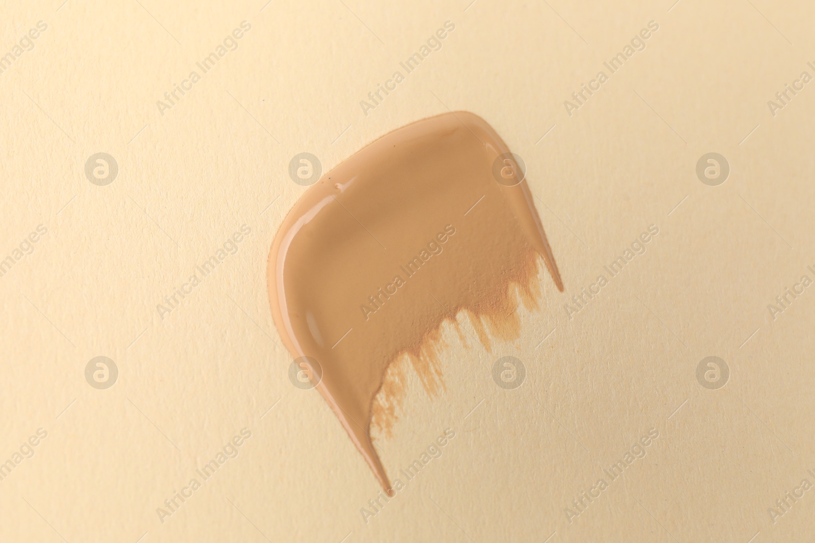 Photo of Sample of foundation on beige background, top view