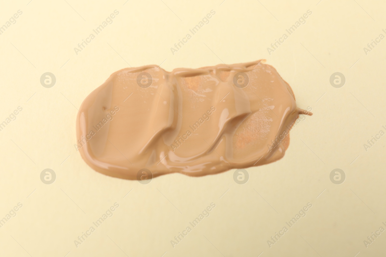 Photo of Sample of luxury foundation on beige background