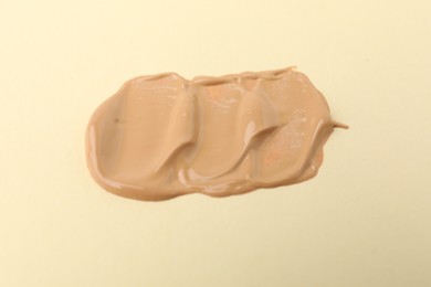 Photo of Sample of luxury foundation on beige background