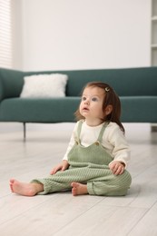 Photo of Cute little baby on floor at home