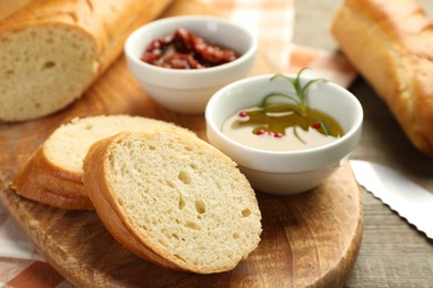 Photo of Cut fresh baguette served on wooden table, closeup