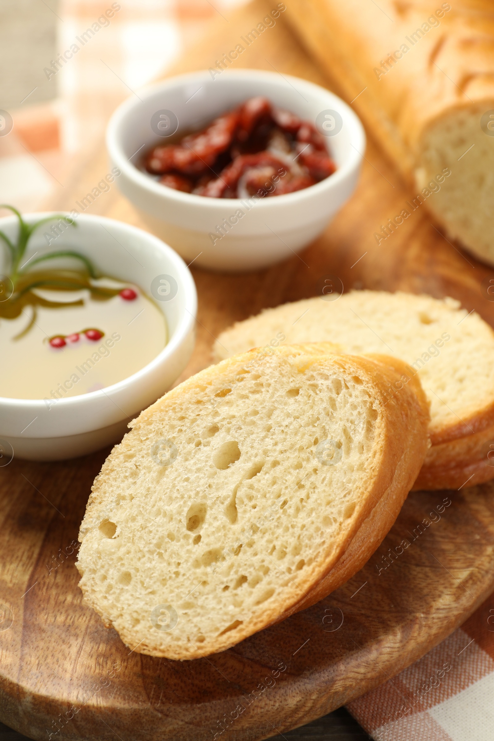 Photo of Cut fresh baguette served on wooden table, closeup