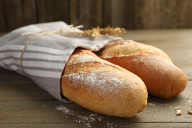 Photo of Freshly baked baguettes on wooden table, closeup