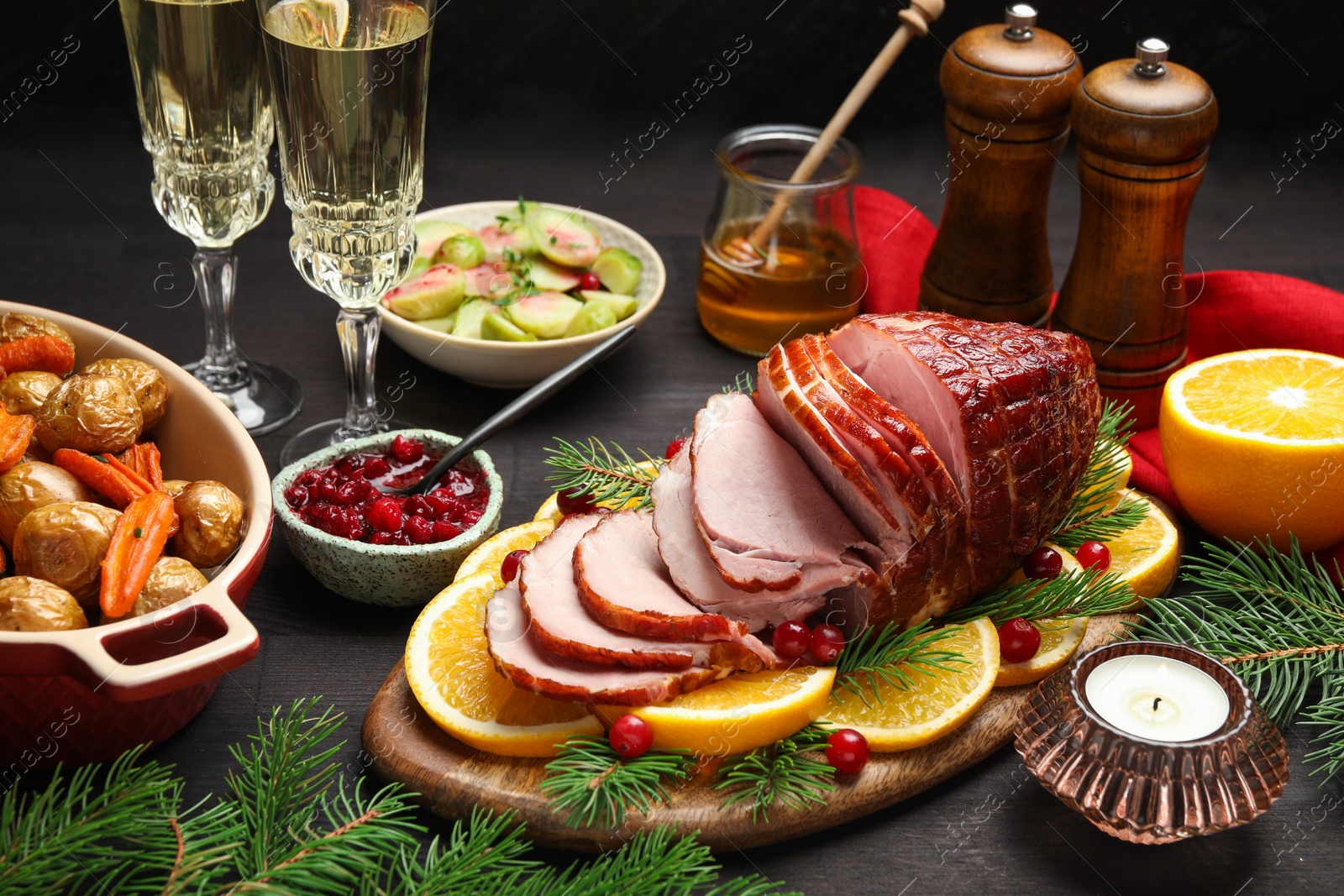 Photo of Tasty baked ham served on black wooden table