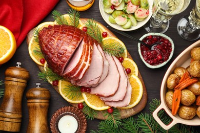 Tasty baked ham served on black wooden table, flat lay