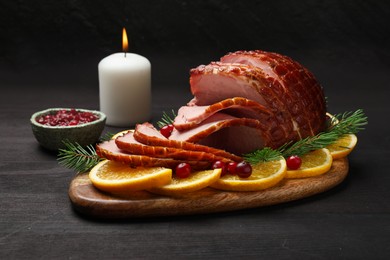 Photo of Tasty baked ham served on black wooden table