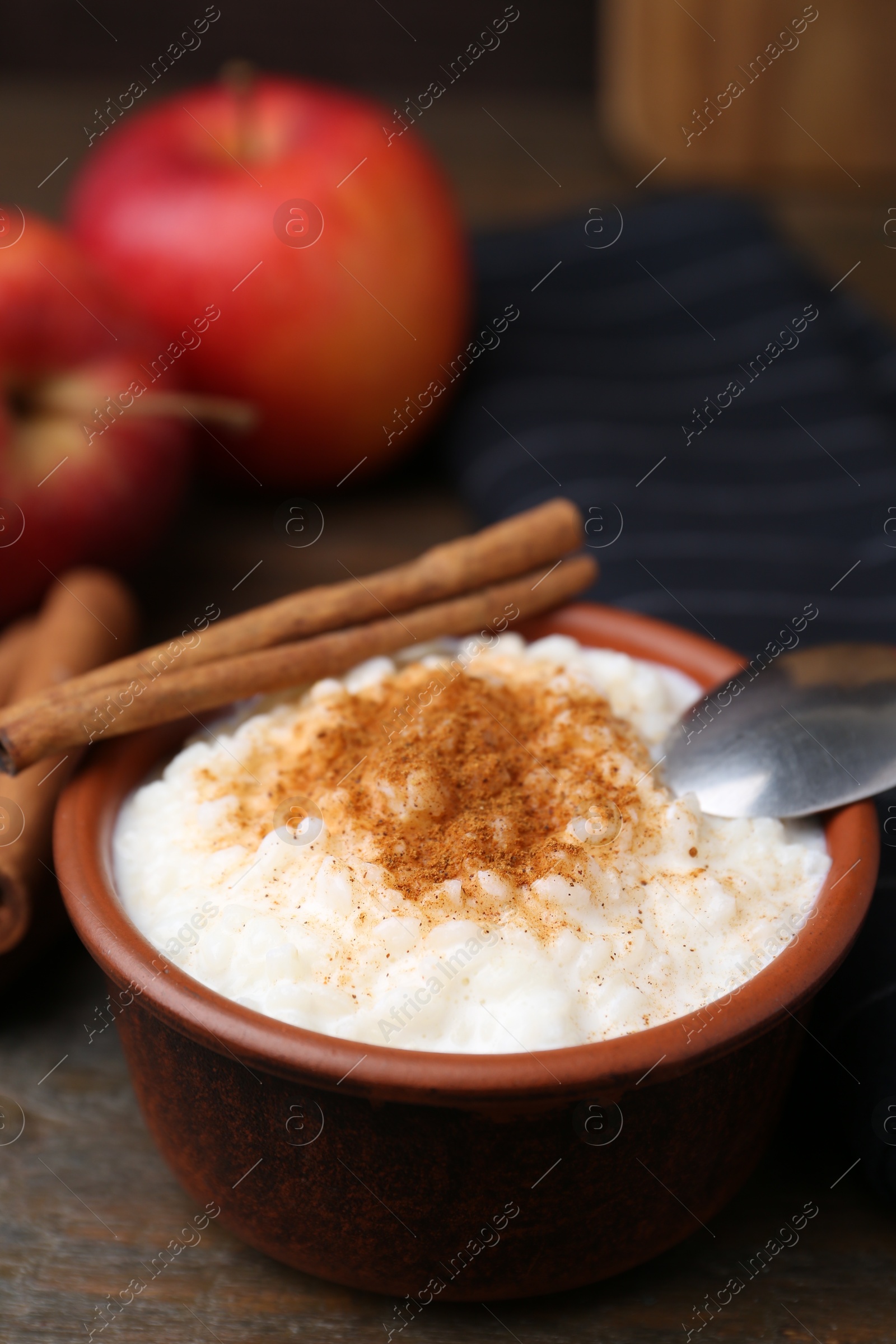 Photo of Delicious rice pudding with cinnamon on wooden table, closeup