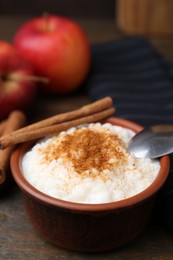 Photo of Delicious rice pudding with cinnamon on wooden table, closeup