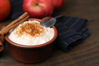 Photo of Delicious rice pudding with cinnamon on wooden table, closeup