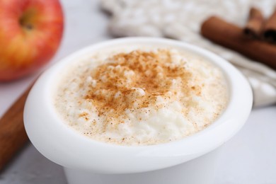 Photo of Delicious rice pudding with cinnamon on table, closeup