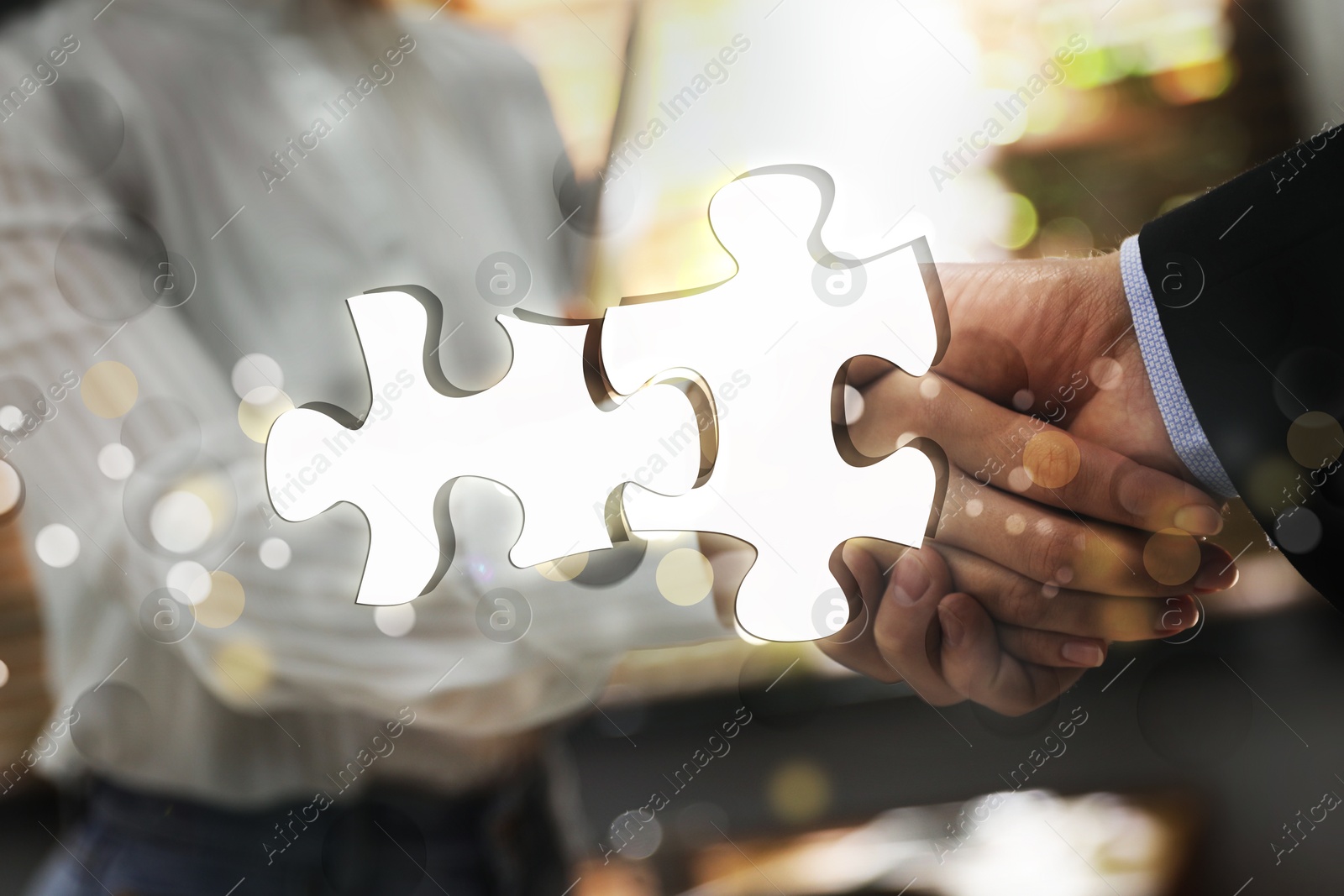 Image of Business partners shaking hands in office, double exposure with joined puzzle pieces