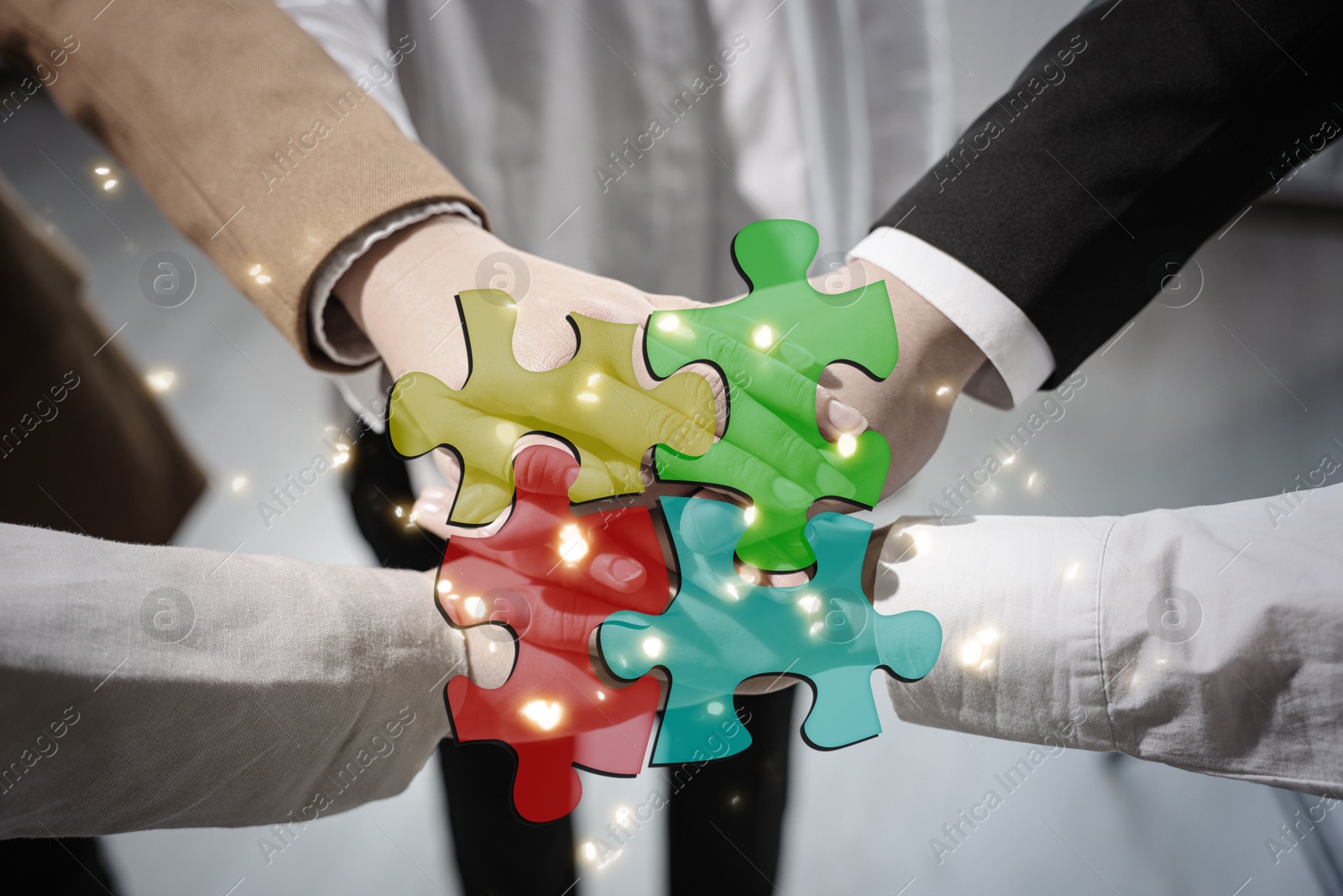 Image of Business partners holding hands together, double exposure with joined puzzle pieces