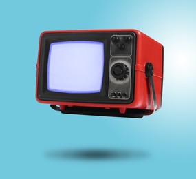 Image of Retro TV set in air on light blue background