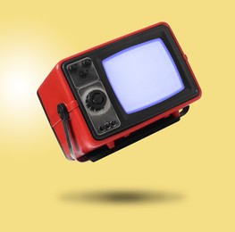 Image of Retro TV set in air on golden background