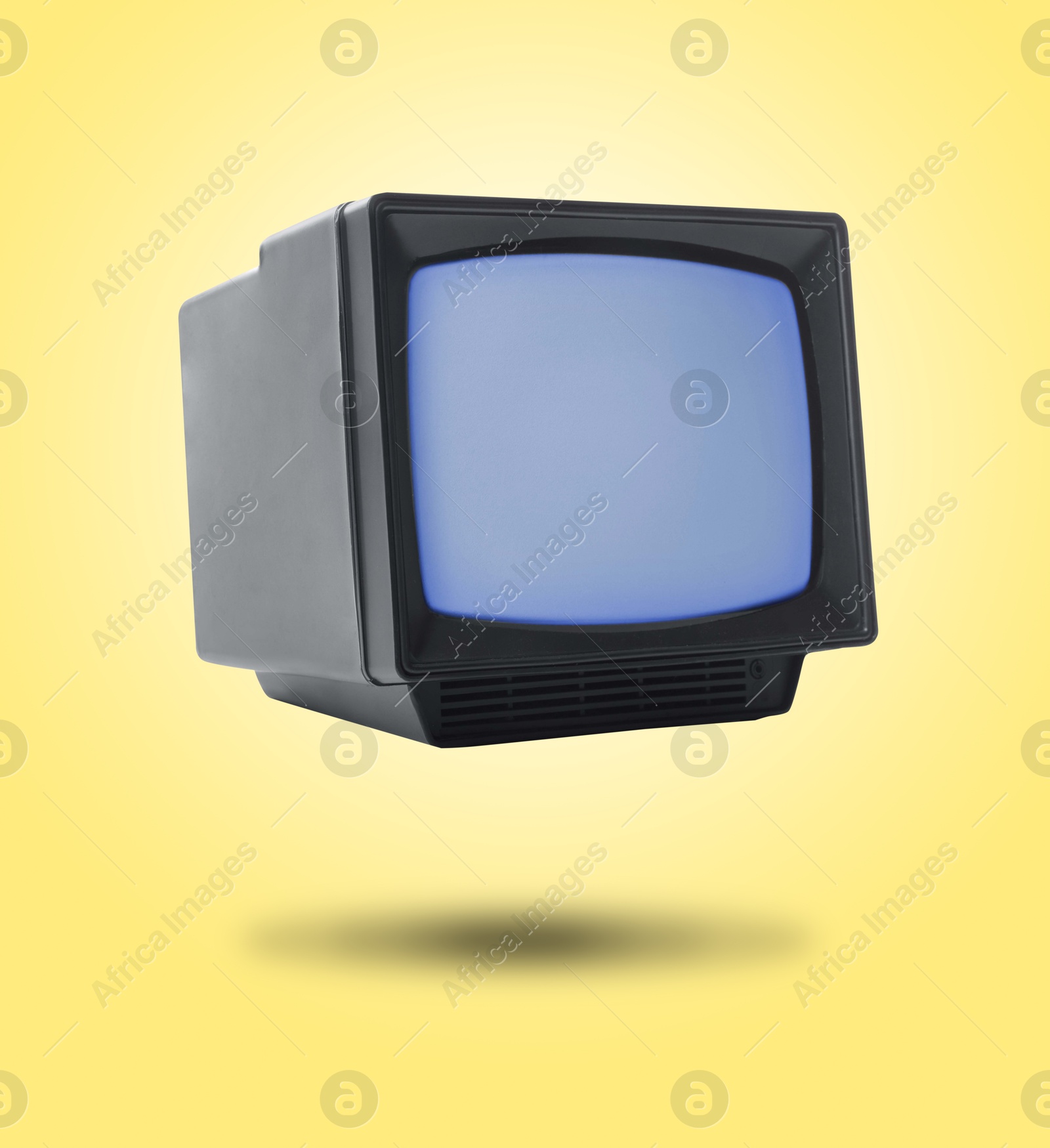 Image of Retro TV set in air on yellow background