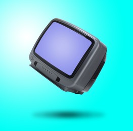 Image of Retro TV set in air on cyan color background