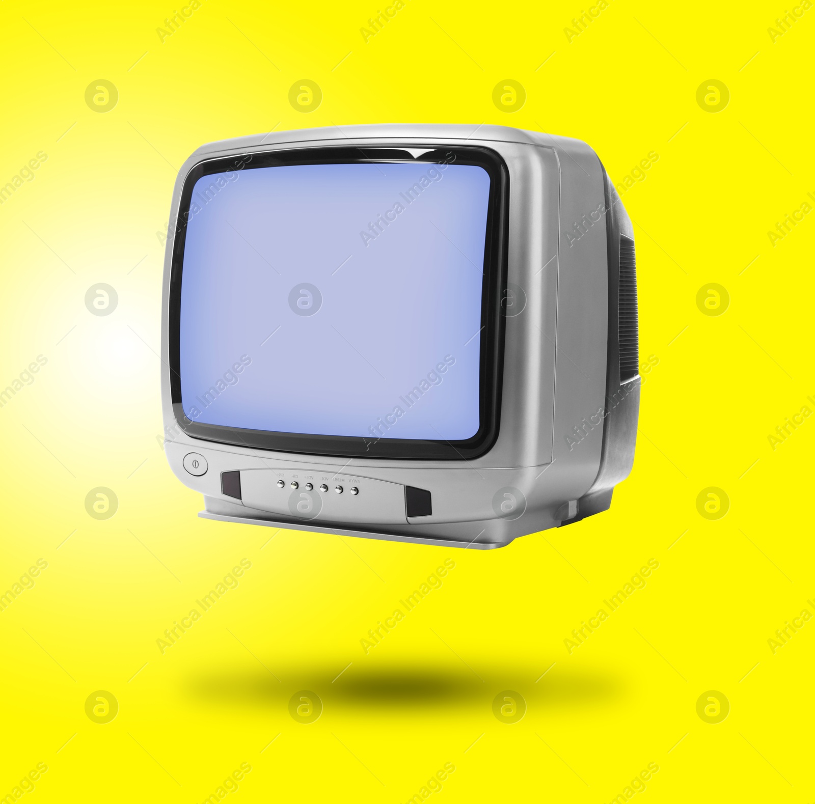 Image of Retro TV set in air on yellow background