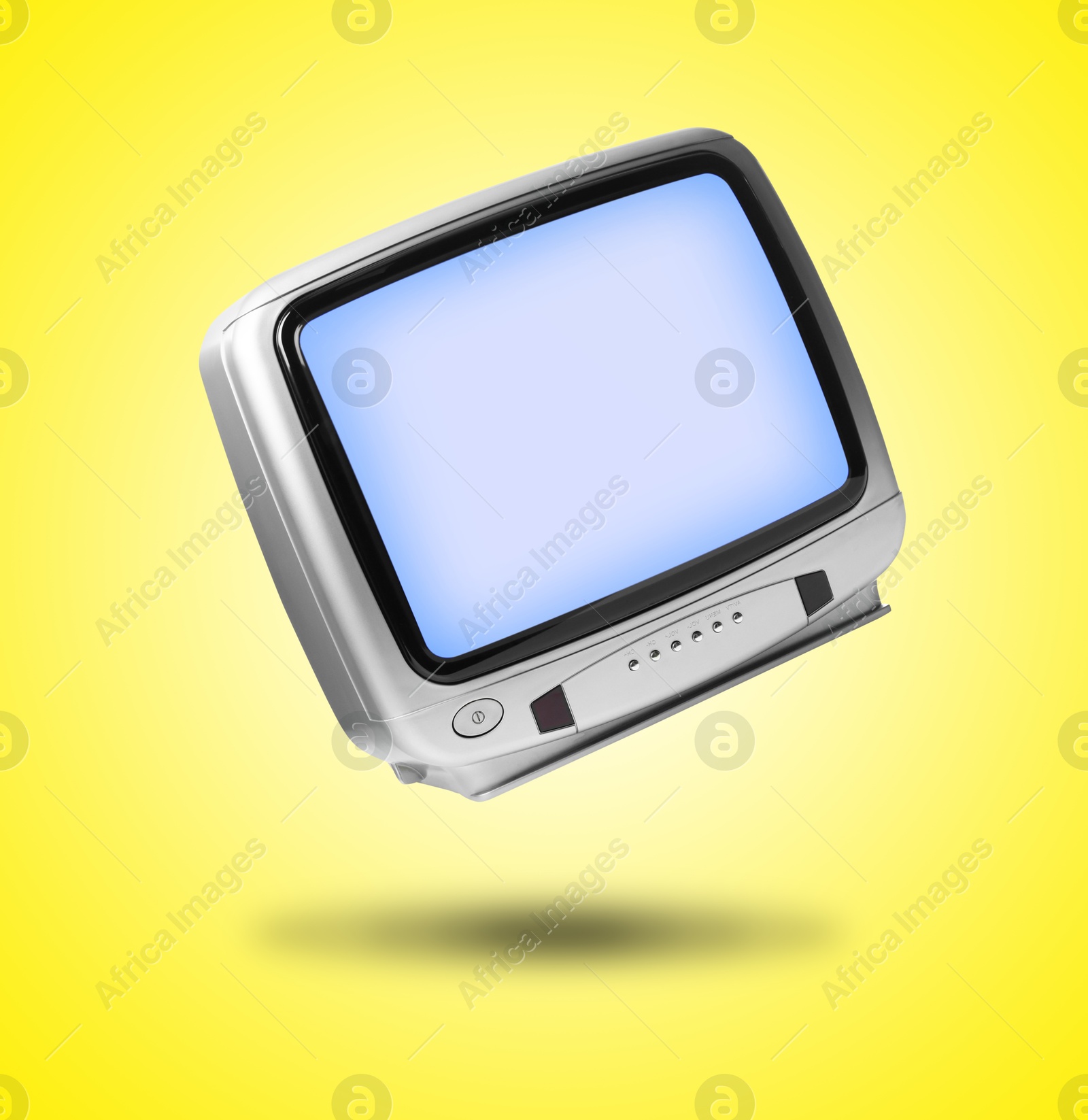 Image of Retro TV set in air on yellow background