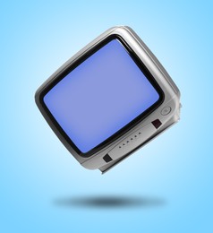 Image of Retro TV set in air on light blue background