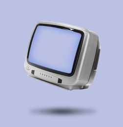 Image of Retro TV set in air on light blue background