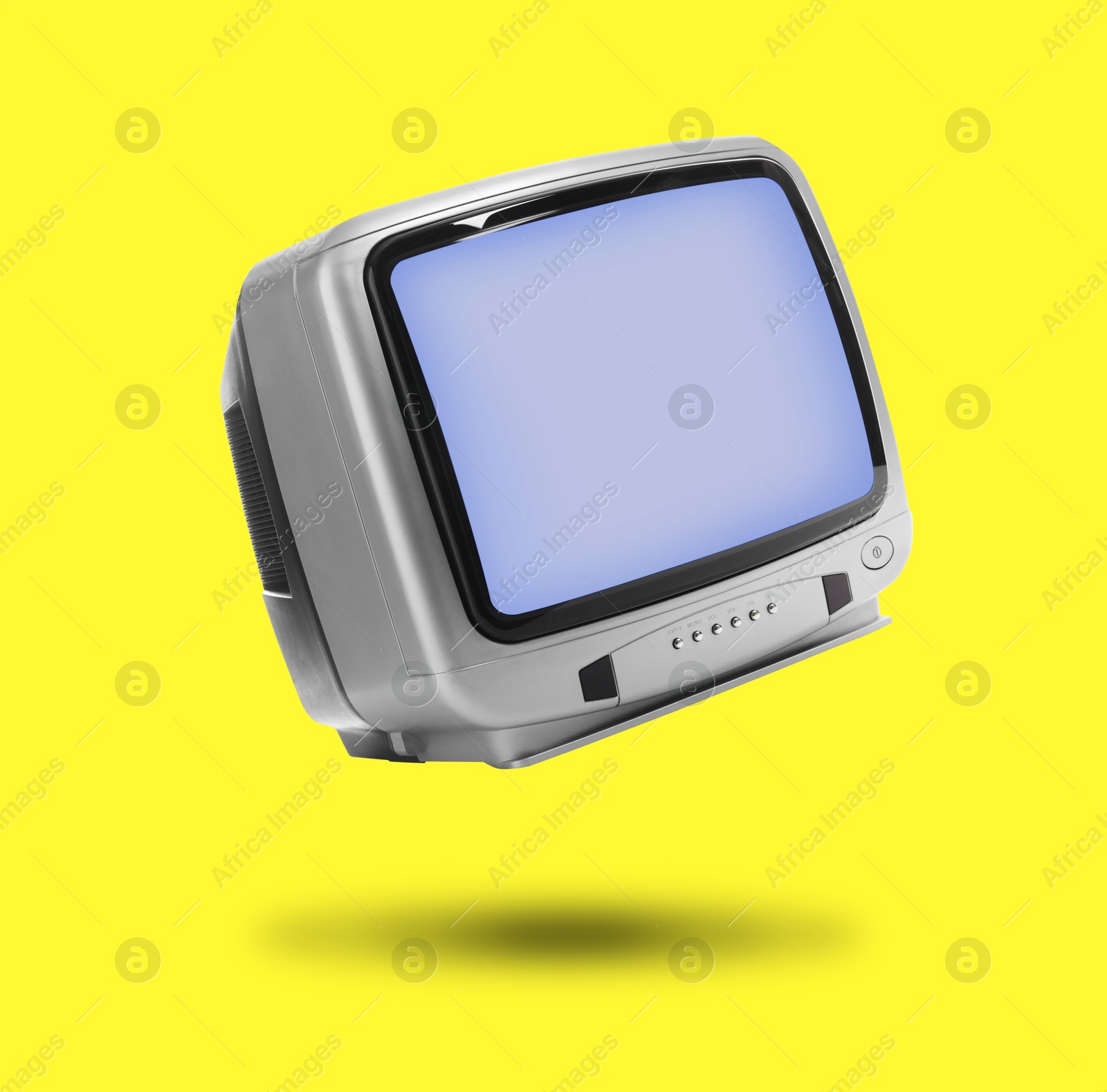 Image of Retro TV set in air on yellow background