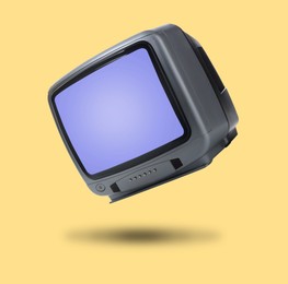 Image of Retro TV set in air on golden background