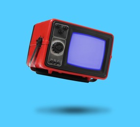 Image of Retro TV set in air on light blue background