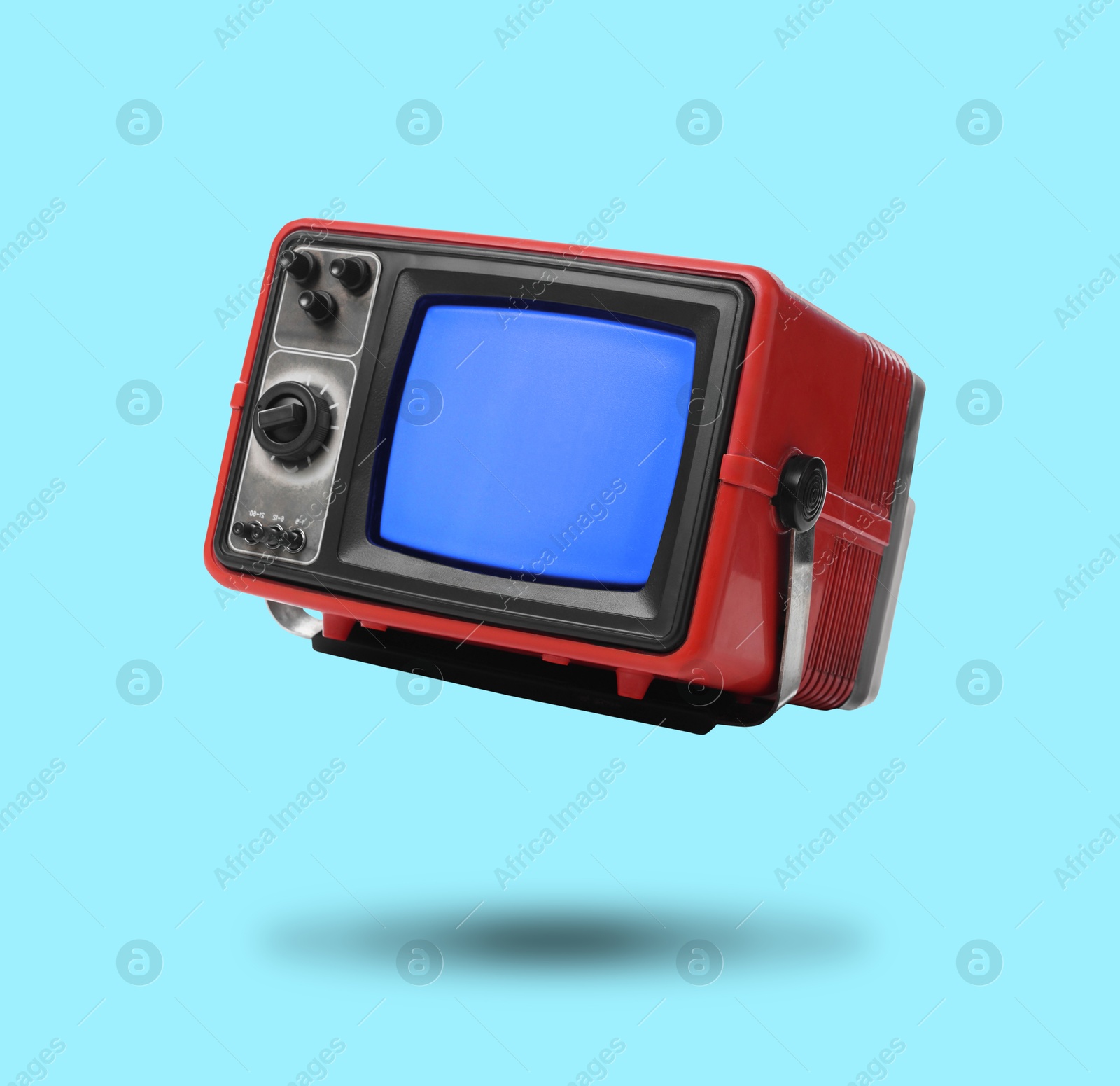 Image of Retro TV set in air on light blue background